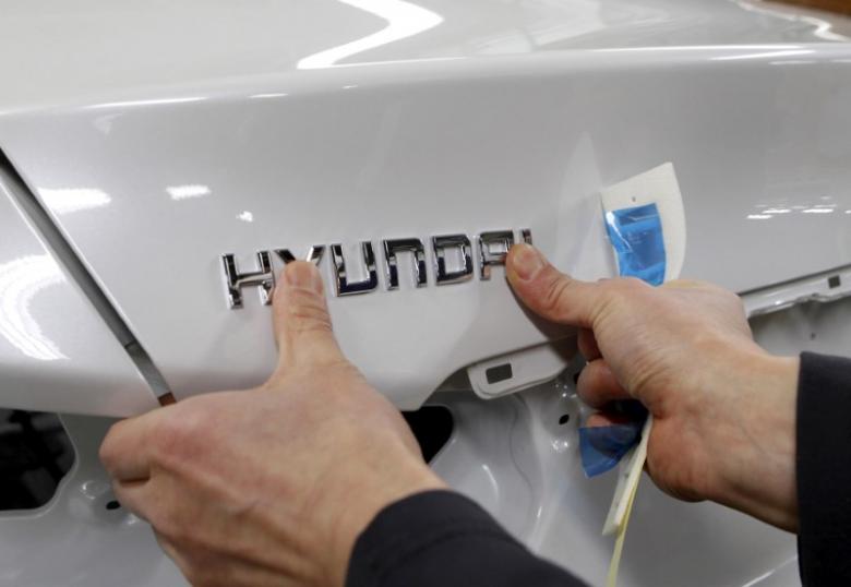 A worker fixes the Hyundai logo on a vehicle at a plant of Hyundai Motor in Asan, south of Seoul, February 9, 2012. REUTERS/Lee Jae-Won/File Photo - RTX2V5PH